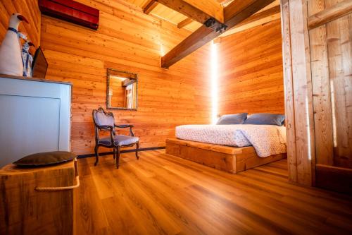 1 dormitorio con 1 cama en una cabaña de madera en Casa di Piero e Marilena, en Candelo