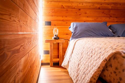 a bedroom with a bed and a wooden wall at Casa di Piero e Marilena in Candelo