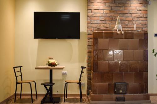 a living room with a tv and a table and chairs at Lana's home in the best part of the city in Vračar (historical)