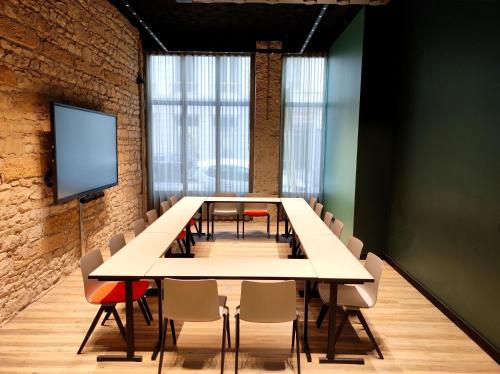 a conference room with a long table and chairs at Hôtel Le Roosevelt Lyon in Lyon