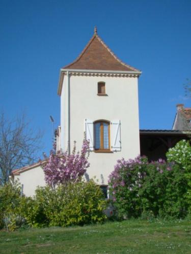 ein weißes Gebäude mit einem Fenster und einigen Büschen in der Unterkunft CHAMBRES D'HOTES LES GRAVES in Saint-Pierre-Lafeuille