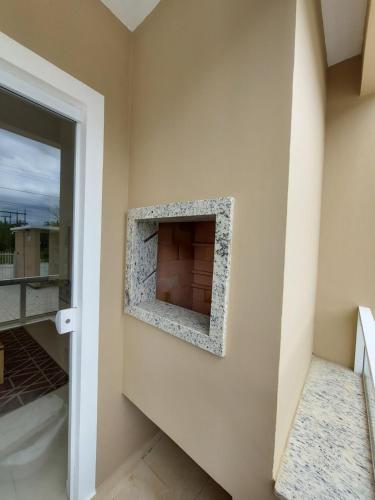 a stone fireplace on the wall of a house at Apartamento Descubra Palhoça - Pinheira in Palhoça