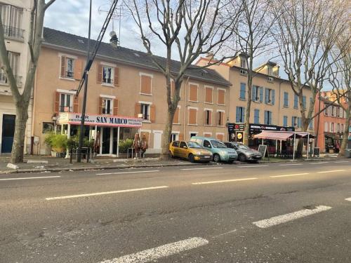 eine Stadtstraße mit Autos, die vor den Gebäuden geparkt sind in der Unterkunft Entre Paris, Versailles et La Défense in Chaville