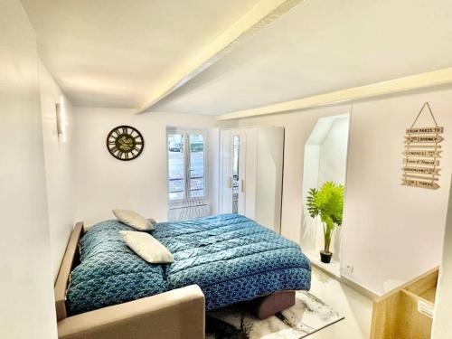 une chambre avec un lit et une horloge au mur dans l'établissement Studio proche de Paris, Versailles et La Défense, à Chaville
