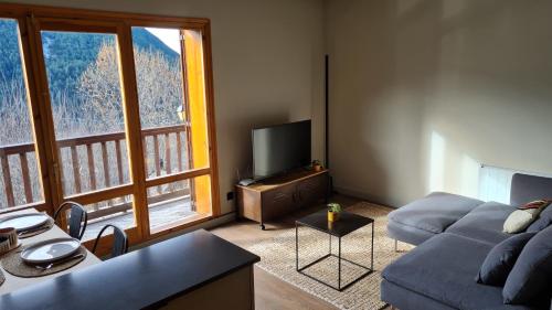 a living room with a couch and a large window at Boí Taüll CALMA I in Taull