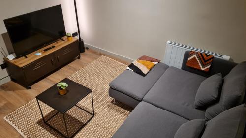 a living room with a couch and a flat screen tv at Boí Taüll CALMA I in Taull