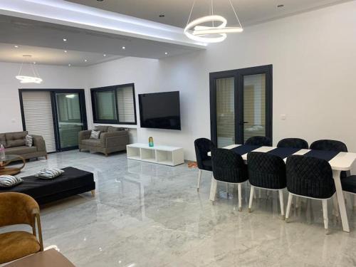 Appartamento di lusso in Tunisia في تونس: غرفة معيشة مع طاولة وكراسي وأريكة