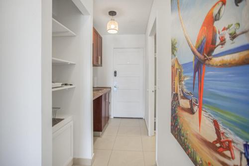 a hallway with a kitchen with a painting on the wall at Maho Beach House - Spacious 2 Bedroom - Ocean View in Maho Reef
