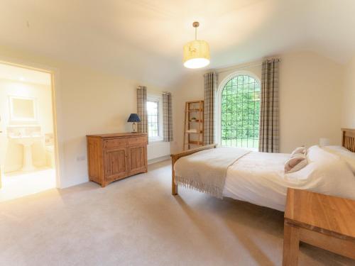 a large bedroom with a bed and a window at The Annexe in Wisley