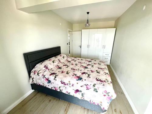 a bedroom with a bed with a floral comforter at Villa Oğuz in Milas