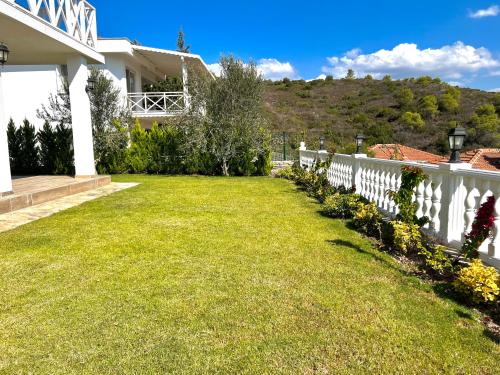a white fence in the yard of a house at Villa Oğuz in Milas