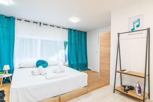 1 dormitorio con 1 cama con cortinas azules y espejo en New Loft in the Heart of City Center, en Heraclión