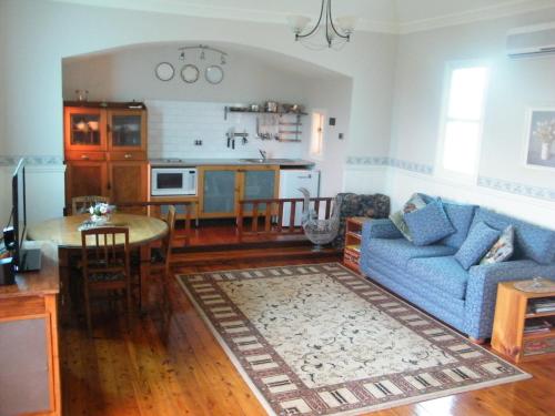 a living room with a blue couch and a table at St Peter's Fairview in Branxton