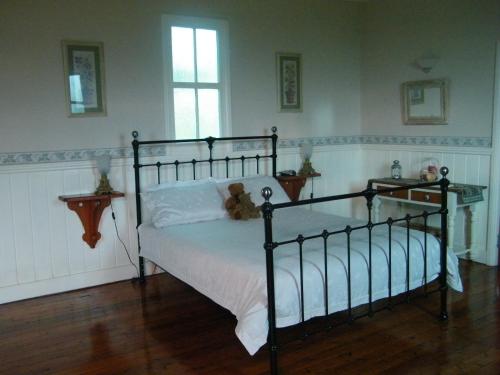 Un dormitorio con una cama con un osito de peluche. en St Peter's Fairview, en Branxton
