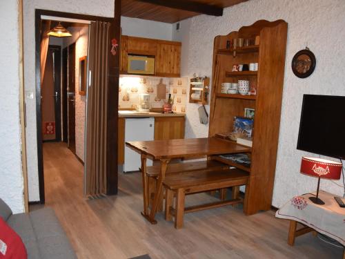 une cuisine avec une table en bois et une salle à manger dans l'établissement Studio pratique pour 4 personnes avec terrasse à Pralognan-la-Vanoise - FR-1-464-50, à Pralognan-la-Vanoise