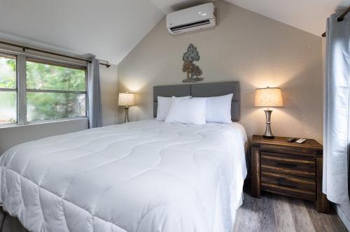 sypialnia z dużym białym łóżkiem i oknem w obiekcie Idlewild Lodge and RV Park w mieście Lake Panasoffkee