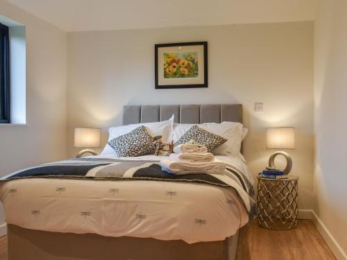 a bedroom with a large bed with two lamps at Post Box Lodge in Dickleburgh