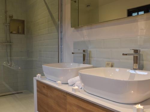ein Bad mit 2 Waschbecken und einer Dusche in der Unterkunft Post Box Lodge in Dickleburgh