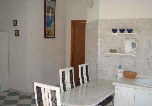 cocina con mesa, sillas y fregadero en Apartments Aurora Borik, en Zadar