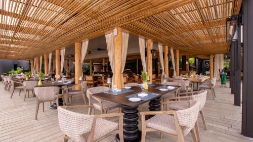 ein Restaurant mit Tischen und Stühlen und einer Holzdecke in der Unterkunft Nayara Tented Camp in Fortuna