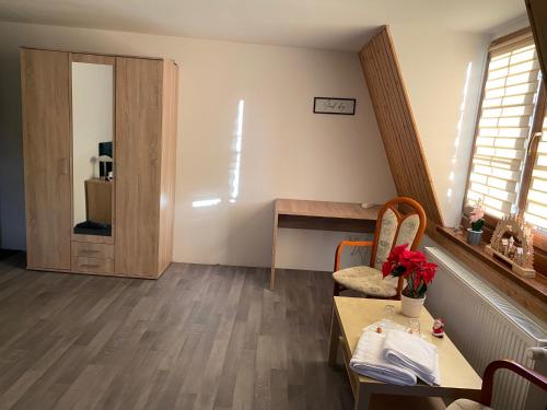 ein Wohnzimmer mit einem Tisch und einem Schreibtisch in der Unterkunft Zimmervermietung Abir in Dresden
