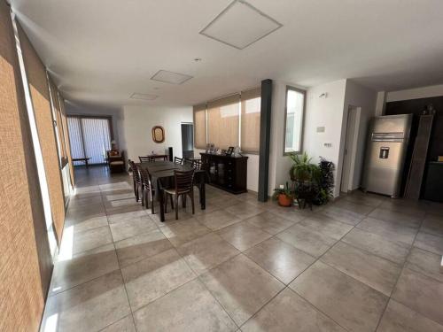 Il comprend un grand salon avec une table et une cuisine. dans l'établissement LUMINOSO piso con jacuzzi, à Alta Gracia