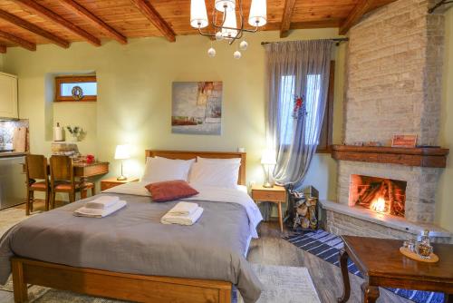 - une chambre avec un grand lit et une cheminée dans l'établissement Ξενώνας Ίταμος, à Kato Trikala Korinthias