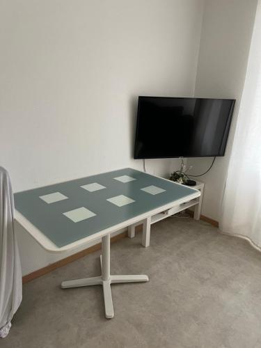 a table in a room with a flat screen tv at Appartement neuf, centre-ville, 400m de rivetoile in Strasbourg