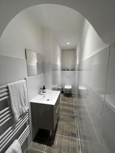 a white bathroom with a sink and a toilet at Appartement neuf, centre-ville, 400m de rivetoile in Strasbourg