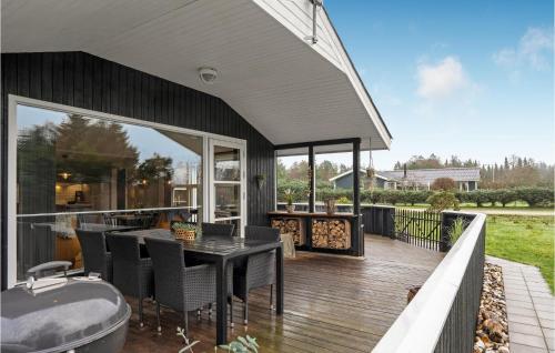 a patio with a table and chairs on a deck at 4 Bedroom Nice Home In Blokhus in Blokhus
