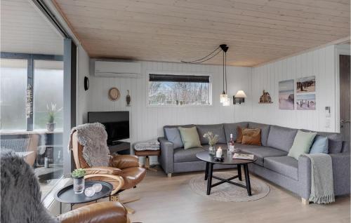 a living room with a couch and a table at 4 Bedroom Nice Home In Blokhus in Blokhus