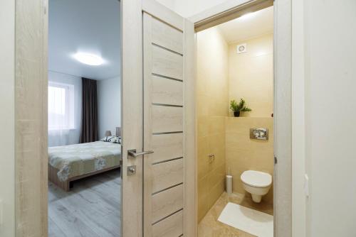 a bathroom with a toilet and a bedroom at Апартаменти на Жасминовій в парковій зоні in Lviv