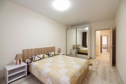 a bedroom with a large bed and a mirror at Апартаменти на Жасминовій в парковій зоні in Lviv