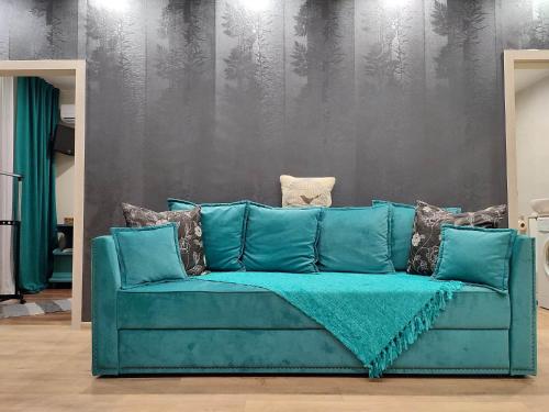 a blue couch in a living room with a wall at Stylish apartment in the historic center in Chernihiv