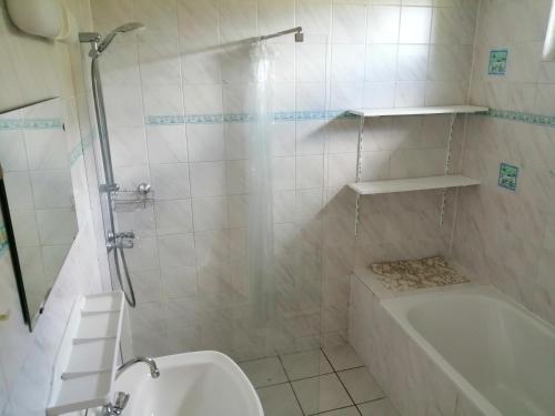 een badkamer met een douche, een bad en een toilet bij Mooie twee-onder-een-kapwoning te Vlagtwedde in Vlagtwedde