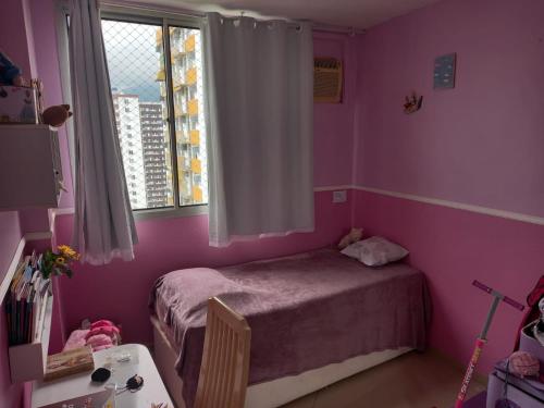 1 dormitorio con paredes rosas y 1 cama con ventana en Barra Beach, en Río de Janeiro