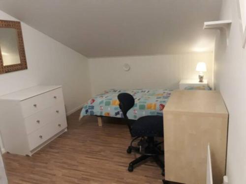 1 dormitorio con cama, escritorio y silla en Rum i fint villa nära centrum, en Jönköping
