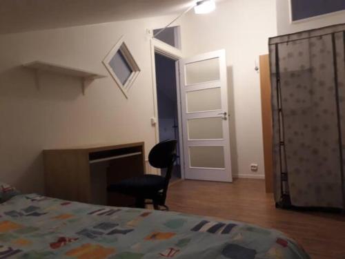 een slaapkamer met een bed en een stoel en een open haard bij Rum i fint villa nära centrum in Jönköping