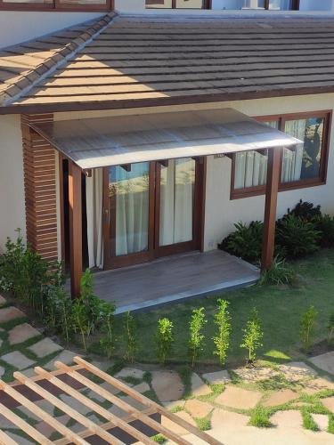 a small house with a porch with a roof at Casa em Barra Grande com piscina in Marau
