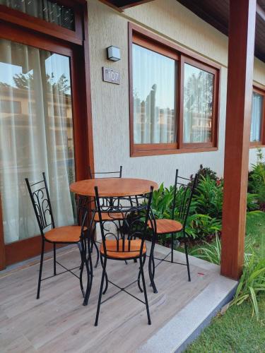 a wooden table and chairs on a porch at Casa em Barra Grande com piscina in Marau