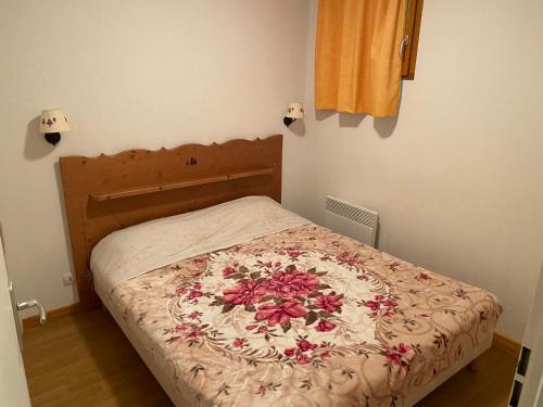 Un dormitorio con una cama con una manta de flores. en residence clos la Chalp II, en Molines-en-Queyras