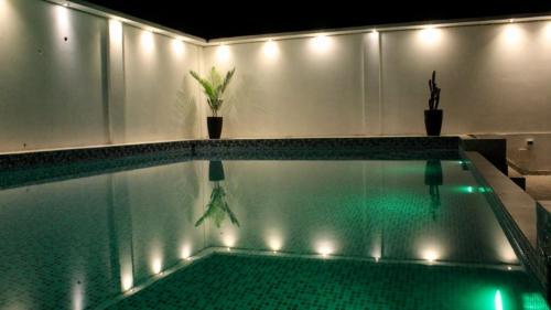 una piscina con luces en una casa en D´Milez Hotel, en Puerto Maldonado