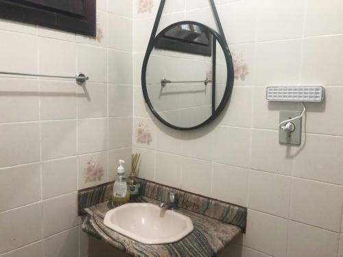 a bathroom with a sink and a mirror at Suíte Trilha do Sol 2 in Arraial do Cabo