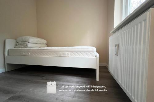 オッテルローにあるBosvakantie Veluwe - Huisje 54, Hoefbos, Otterloの窓付きの客室の白いベッド1台