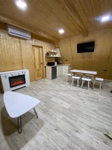 a room with tables and chairs and a fireplace at Green Villa Resort White in Dilijan