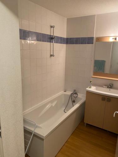 y baño con bañera y lavamanos. en residence clos la Chalp II, en Molines-en-Queyras