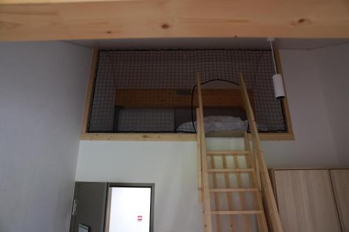 a bunk bed in a room with a ladder at L'auberge de Noiraigue in Noiraigue