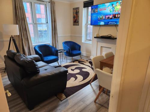 2-bedroom flat in Cutty-Sark, Greenwich ! في لندن: غرفة معيشة مع أريكة وكرسيين وتلفزيون