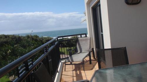 a balcony with a chair and a view of the ocean at The Sands Unit 9 in Yamba