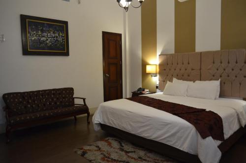 a bedroom with a large bed and a chair at Hotel Patrimonial by Greenfield in Guayaquil